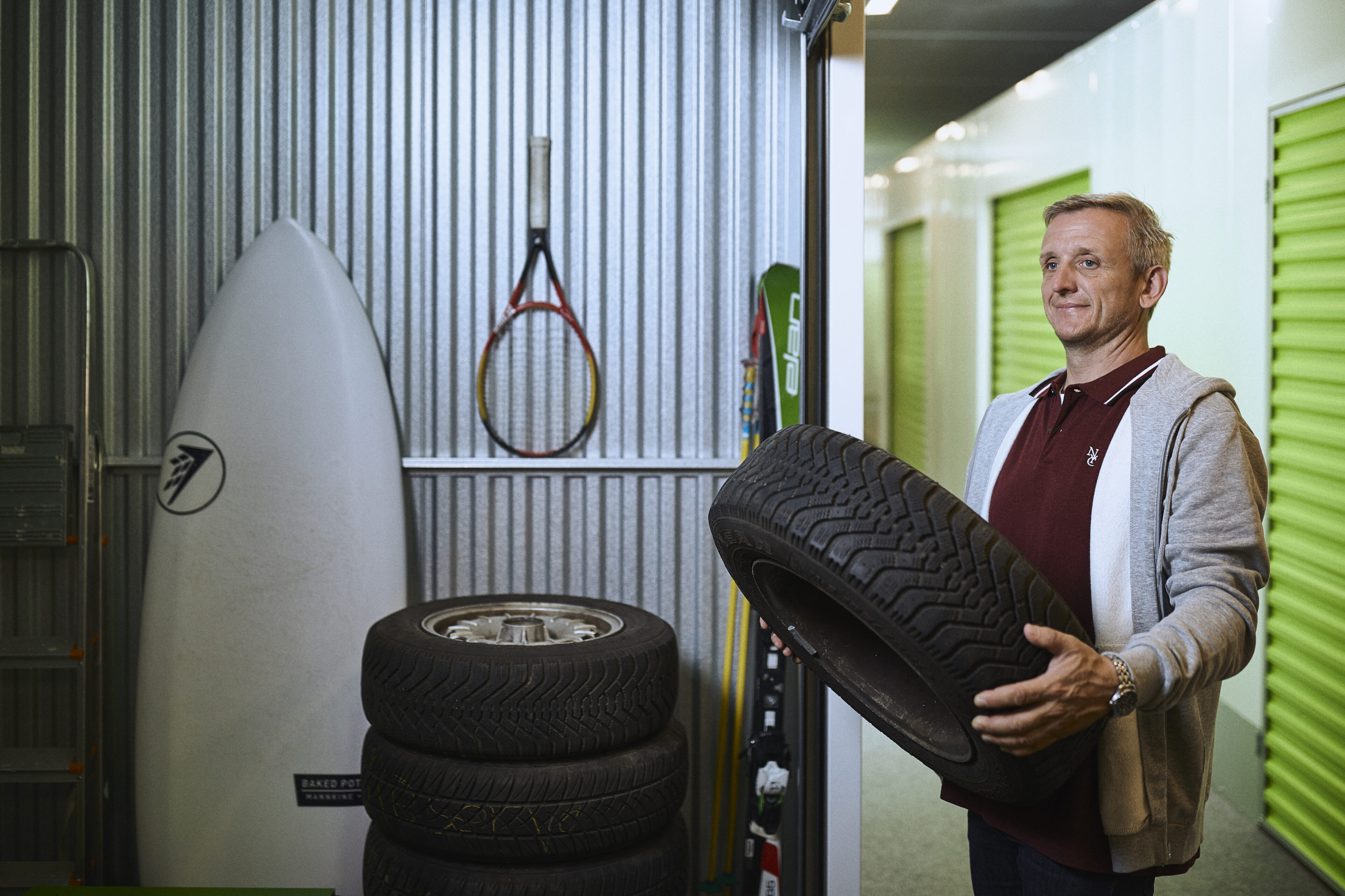 Man with tyres in a storage unit at Pelican Self Storage
